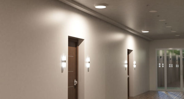 A hallway with two doors, both with wall lights and a single round bulkhead light on the ceiling as illumination.