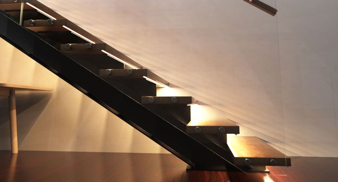 The side of a staircase with warm lights under every step.
