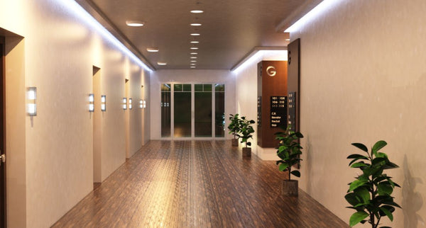 A hotel ground floor corridor with multiple ceiling lights and LED strip lighting along the ceiling.