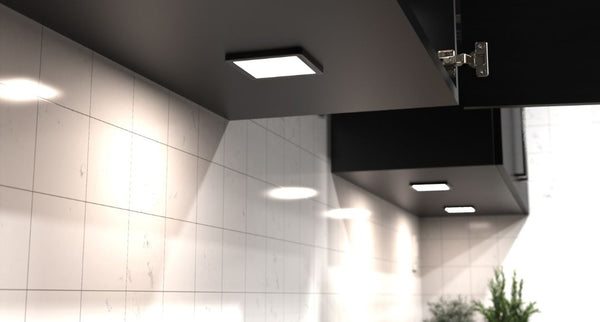 Under cabinet lights installed beneath a black hanging kitchen cabinet.