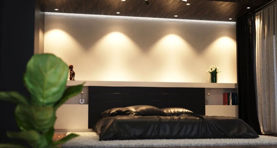 Warmly lit bedroom with dark walls and beddings.
