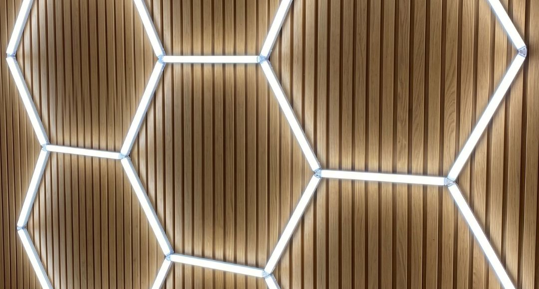 Wooden wall with cool white hexagon lights installed.