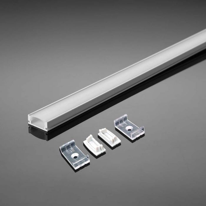 An aluminium profile with a white diffuser laid on a reflective grey surface, along with two mounting brackets and clips.