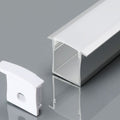 A close-up image of the recessed profile with a white diffuser and an end cap, laid on a reflective grey surface.