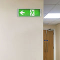 ExitGuardian - LED Exit Signage - Illuminated emergency exit sign in a hallway with arrow left label