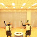 Simple Lighting - PAN 1230 LED Panel Light - An office lounge and desk areas illuminated by a set of warm LED panels.