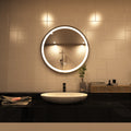 Black LED bathroom mirror above the sink setting in warm white light