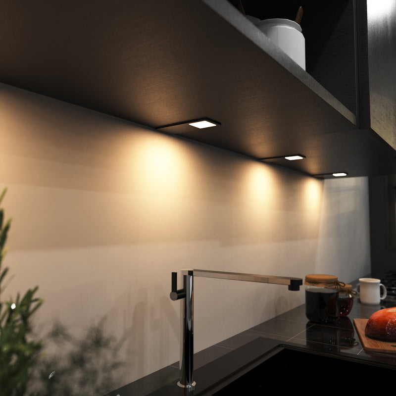 mid-shot of a kitchen with mounted black LED CCT cabinet lights - warm white light