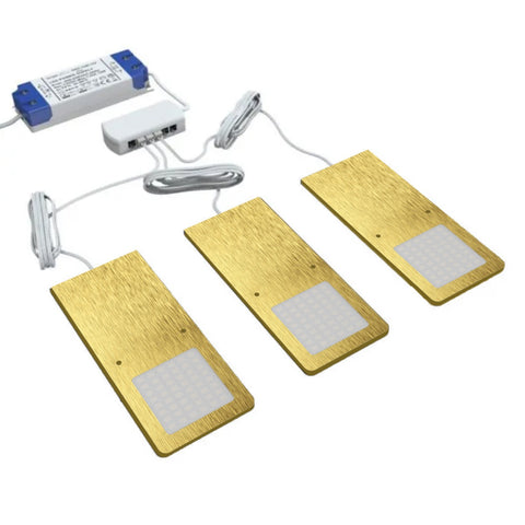 Three brushed brass under cabinet lights connected to a single LED driver.