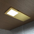 Cool white glow on the ultra-slim brushed brass under cabinet light mounted under a wooden surface.