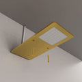 The brushed brass under cabinet light with two screws pointed to their respective holes for installation.