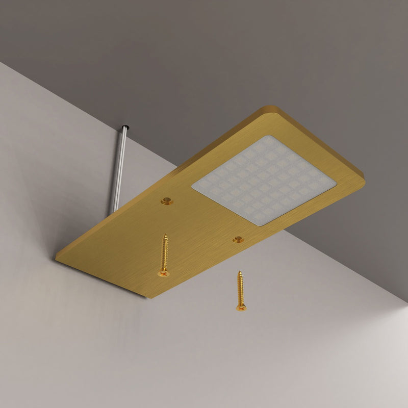 A suspended slim under cabinet light with a brushed brass finish with 2 screws pointed at its dedicated screwing holes.