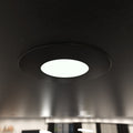 close-up shot of a mounted matt black downlight with natural white light