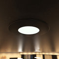 close-up shot of a mounted matt black downlight with warm white light