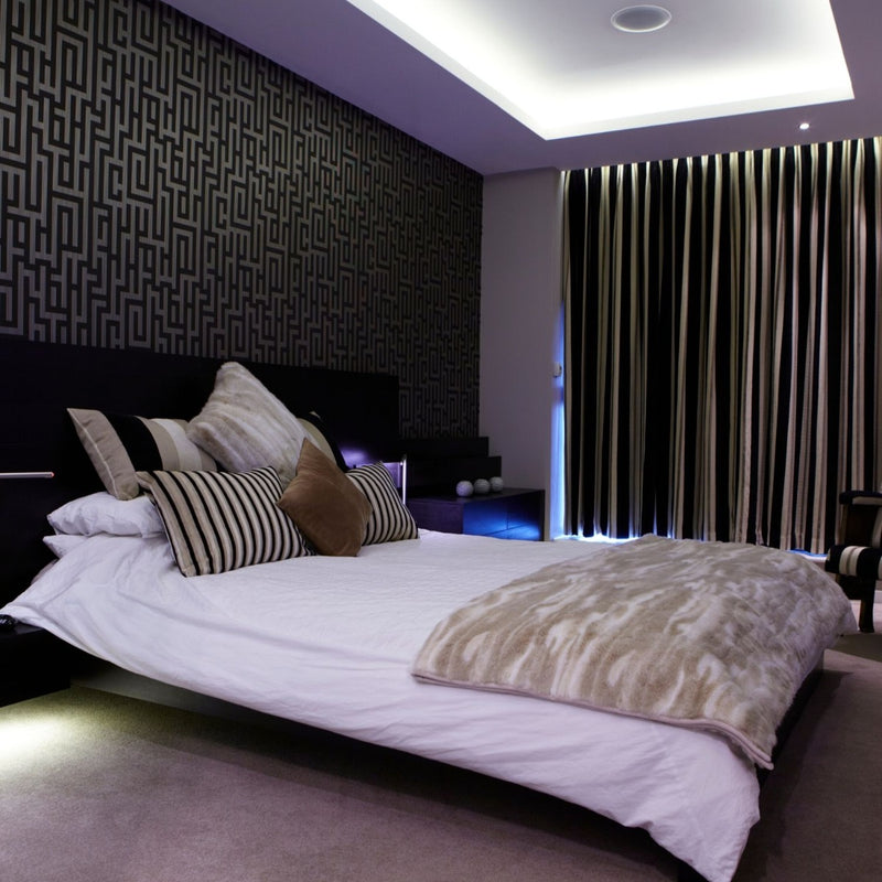 Full shot of a bedroom with LED tape with cool white light in the ceiling 