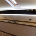 Side shot of a kitchen cabinet with LED tape with cool white light