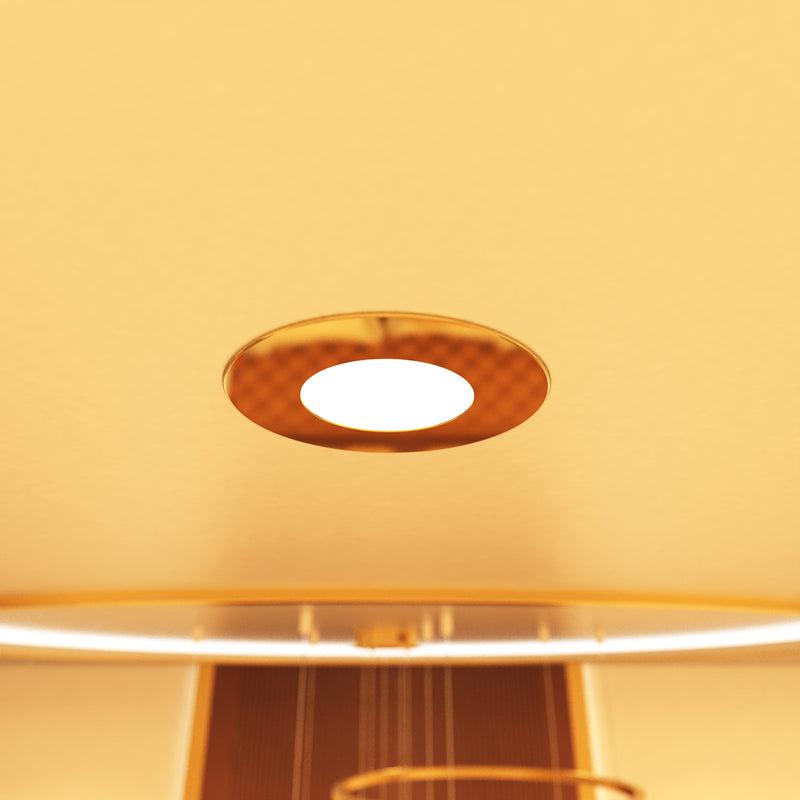 close up shot of a mounted brass LED downlight with warm white light