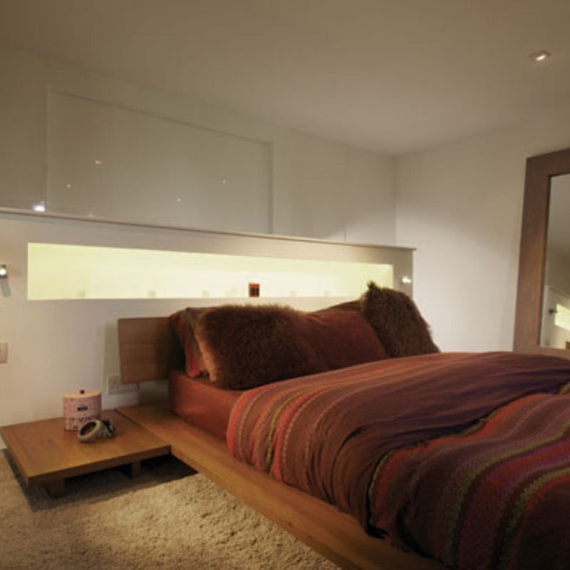 Full shot of a room with LED tape in natural white light on the back of the bed
