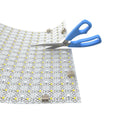 LED sheet being trimmed with a scissors