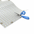 LED sheet being cut with a scissor