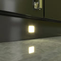 Close-up of a mounted square LED plinth light with warm white light