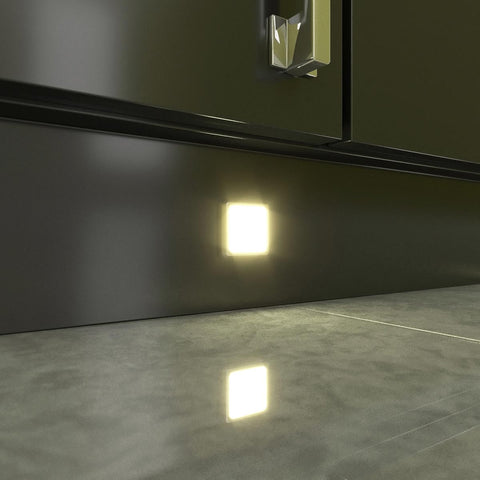 Close-up of a mounted square LED plinth light with warm white light