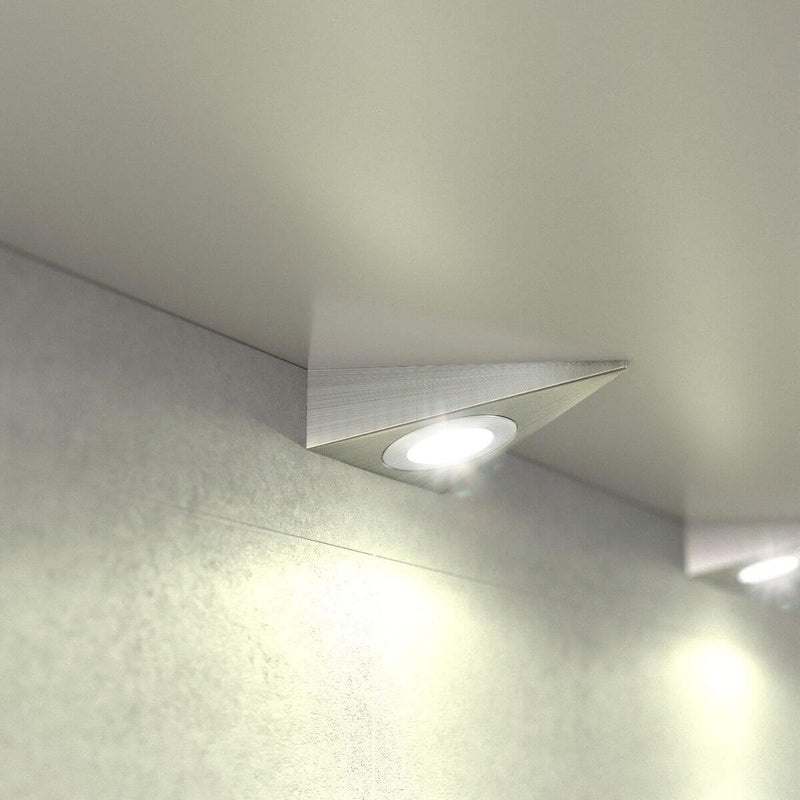 Close-up of a mounted triangle under cabinet light in a warm white light