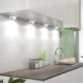 Side view of a kitchen with four triangle under cabinet lights with a cool white light