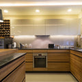 Full shot of a kitchen with LED tape in warm white light on the ceiling